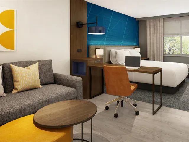 Furnished hotel guest room with bed and casegoods